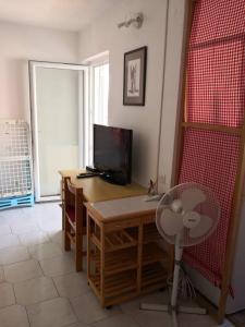 a room with a desk with a television and a table at Apartments "Laci" in Krk