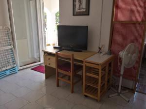 a room with a desk with a television and a fan at Apartments "Laci" in Krk