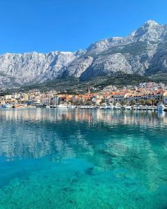 a view of a town on the water with mountains at Apartment Edgar in Makarska