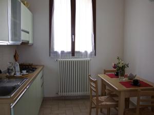 kuchnia ze stołem, oknem i grzejnikiem w obiekcie Belvilla by OYO Gesso Piccolo w mieście Sassoleone