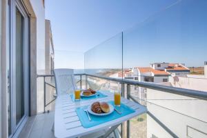 a table with two plates of food on a balcony at São Bernardino Beach Bay Apartment - BB in São Bernardino