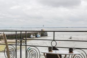 a table and chairs on a balcony overlooking the beach at La Bisquine - Appt pour 4 avec vue mer in Cancale +7 photos