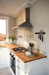 a kitchen with a stove and a counter top at Charming Three Bed Home Near City Centre and Hospital in Southampton