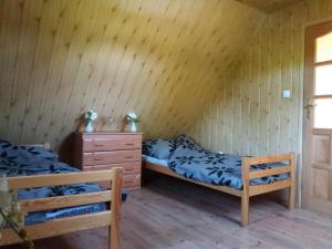 2 camas en una habitación con paredes de madera en Agroturystyka Józefówka Borkowo Lęborskie, en Zwartowko 
