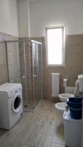 a bathroom with a washing machine and a toilet at Casa Vacanze Leo 2 in Acquarica del Capo