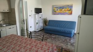 a living room with a blue couch and a table at Casa Vacanze Leo 2 in Acquarica del Capo