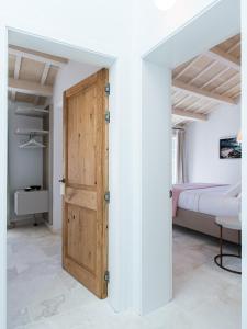 a bedroom with a wooden door and a bed at Samarés in Ciutadella