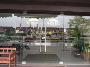 a window of a restaurant with a reflection of a street at Radiant Hotel in Sitiawan