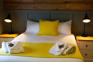 a bedroom with a bed with towels on it at The Poacher Inn in Upton Grey