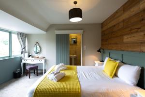 a bedroom with a large bed with a wooden headboard at The Poacher Inn in Upton Grey