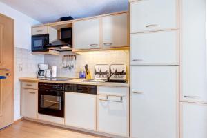 eine Küche mit weißen Geräten und einem weißen Kühlschrank in der Unterkunft Haus Berlin Krabbengalerie in Loddin