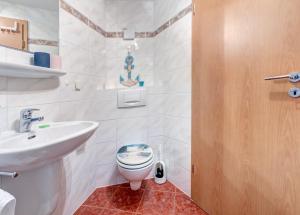 a bathroom with a toilet and a sink at Haus Berlin Krabbengalerie in Loddin
