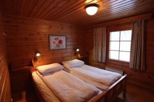 a bedroom with two beds in a wooden room at Hapimag Ferienwohnungen Punkaharju in Punkaharju