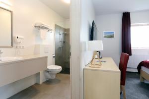 a white bathroom with a sink and a toilet at Hótel Eyjafjallajökull in Hellisholar