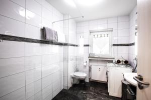 ein weißes Badezimmer mit Toilette und Waschbecken in der Unterkunft Sweet Home & Flower Garden in Garmisch-Partenkirchen