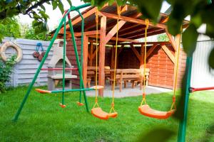a swing set in a yard with a house at Domek we Władku in Władysławowo