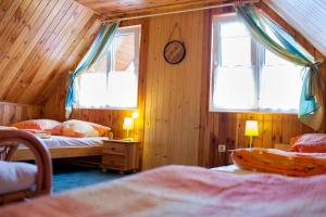 a bedroom with two beds and two windows at Domek we Władku in Władysławowo