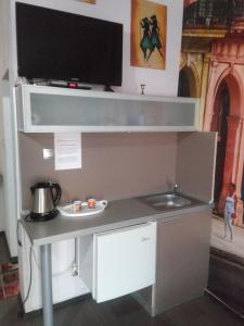 a desk with a sink and a tv on a wall at Самостоятелни студия in Kŭrdzhali