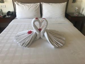 a white bed with white sheets and a white towel on top of it at Trident Agra in Agra