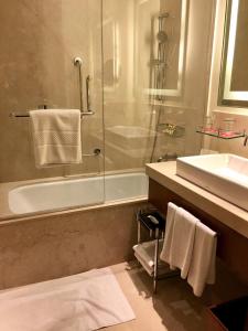 a bathroom with a tub, toilet and sink at Trident Agra in Agra