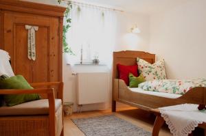 a bedroom with a bed and a chair and a window at Gästehaus Minkel in Gudensberg