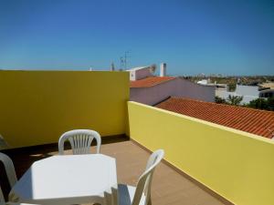 a balcony with a table and chairs on a roof at Casa Amarela by Umbral in Pêra