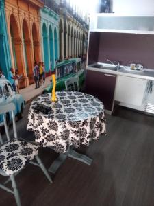 eine Küche mit einem Tisch und einem Waschbecken sowie einem Tisch und Stühlen in der Unterkunft Самостоятелни студия in Kardschali