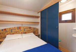 a small bedroom with a bed and a window at Camping Village Poljana in Mali Lošinj