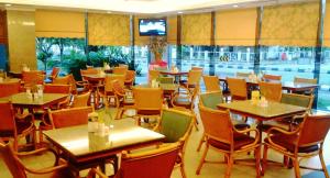 a restaurant with tables and chairs and a television at Hotel Grand Continental Kuantan in Kuantan