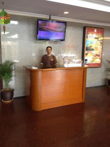 a man standing behind a bar in a restaurant at Hotel Grand Continental Kuantan in Kuantan