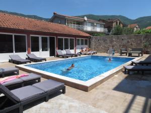 a swimming pool with people in the water at Guest House Villa Živanović in Herceg-Novi