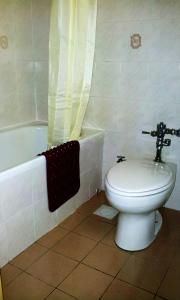 a bathroom with a toilet and a bath tub at Hotel Grand Continental Kuantan in Kuantan