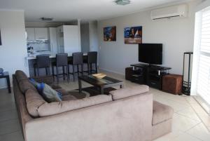 a living room filled with furniture and a tv at Surfside On The Beach in Buddina