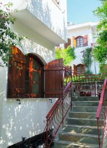 un conjunto de escaleras que conducen a un edificio con puertas de madera en Villa Mikra Asia, en Poros
