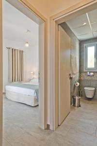 een slaapkamer met een bed en een badkamer met een toilet bij Anatoli Villas in Amoopi