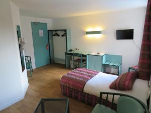 a hotel room with a bed and a desk at Le Relais de Voisins in Voisins-le-Bretonneux