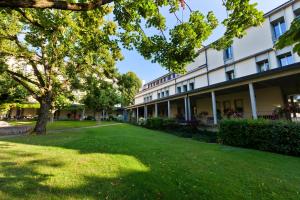 a large building with a green lawn in front of it at Hotel La Longeraie in Morges