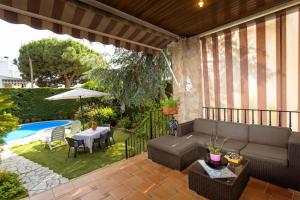 a patio with a couch and a table next to a pool at Villa Paquita in Calella