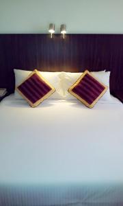 Una cama con dos almohadas encima. en Hotel Grand Continental Kuantan, en Kuantan