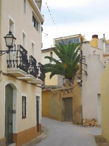 een steegje in een oud gebouw met een palmboom bij Casa rural ca l'Antoni (Tarragona) in Nulles