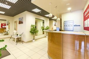 a lobby of a pharmacy with a counter and chairs at Hotel England Tyumen Center in Tyumen