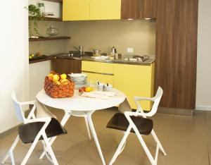 una cucina con tavolo bianco e cesto di frutta di Residence Alleterme a Rivanazzano