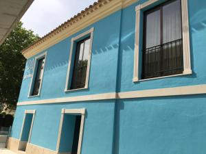 un edificio azul con ventanas en una calle en Apartamentos Jardines de Lorca, en Lorca