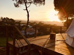 a wooden deck with a tent in the sunset at Oasis Backpackers Hostel Sintra Surf in Sintra
