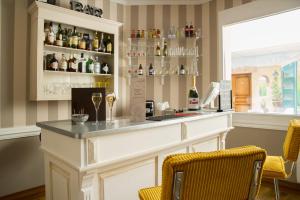 a bar in a room with chairs and bottles of wine at Hotel Eden in Béthune