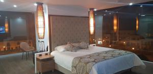 um quarto com uma cama, uma cadeira e uma janela em Hotel Amiraty em Ipiales