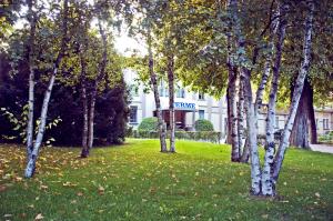 a group of trees in the grass in front of a building at Residence Alleterme in Rivanazzano