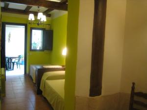 Habitación con 1 dormitorio con paredes verdes y 1 cama. en Casa rural ca l'Antoni (Tarragona), en Nulles