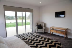 um quarto com uma cama, uma secretária e uma televisão em Relbia Lodge em Relbia