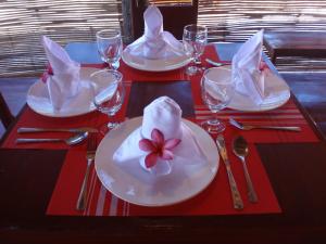 a table with white plates with a flower on it at Winyanz Tambayan Tourist Inn in Siquijor